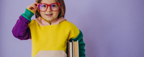 Cute little girl holding books isolated in studio